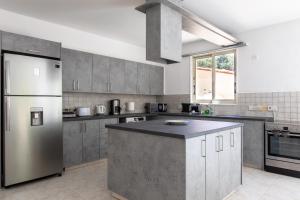 a kitchen with a stainless steel refrigerator and cabinets at Gaia - 4 Bedroom House in Larnaca in Larnaca