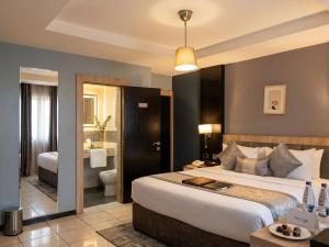 a hotel room with a large bed and a bathroom at Edge ONE Resort in Gwarinpa