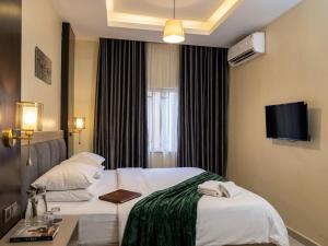 a hotel room with a bed and a tv at Edge ONE Resort in Gwarinpa +3 photos