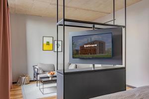 a room with a bed with a flat screen tv at ipartment Leverkusen @HOME by Best Western in Leverkusen