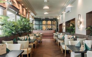 a dining room with tables and chairs at Aqua Hotel Termál in Mosonmagyaróvár