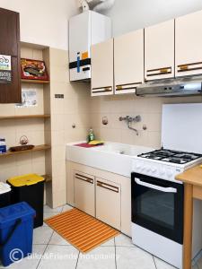 a kitchen with white cabinets and a stove and a sink at CASA BETTI in Pesaro