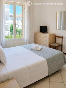 a bedroom with a large white bed and a chair at CASA BETTI in Pesaro