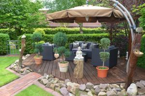 a patio with a couch and an umbrella at Ferienhaus Nikki 35528 in Uplengen