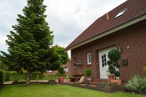 a house with a tree in the yard at Ferienhaus Nikki 35528 in Uplengen