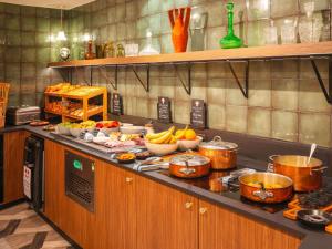 a kitchen with pots and pans and food on a counter at Le Splendid Hotel Lac D'Annecy - Handwritten Collection in Annecy