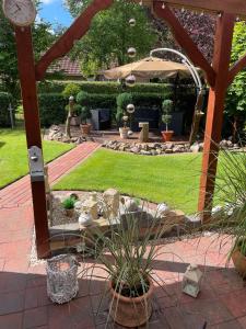 a garden with an umbrella and potted plants at Ferienhaus Nikki 35528 in Uplengen