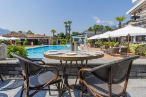 a table and two chairs and a pool at Parkhotel Delta, Wellbeing Resort in Ascona