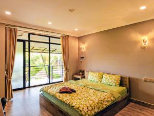 a bedroom with a bed and a large window at Funky Moon Kampot in Kampot