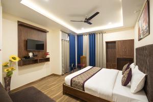 a hotel room with a bed and a tv at Hotel Kamal Palace in Lucknow