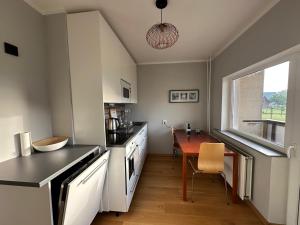 a kitchen with a table and a dining room at Viskoosa Näkmani Apartment in Kõrgessaare