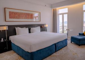 ein Schlafzimmer mit einem großen Bett und einem blauen Stuhl in der Unterkunft K108 Hotel Doha in Doha + 56 Fotos