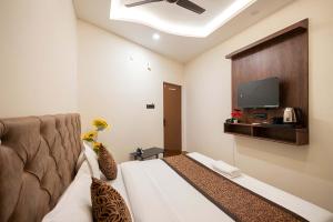 a hotel room with a bed and a flat screen tv at Hotel Kamal Palace in Lucknow