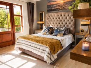 a bedroom with a large bed and a window at Captains Quarters in Plettenberg Bay +37 photos