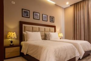 a bedroom with two beds with white sheets and two lamps at Hotel Magllara in Sarandë