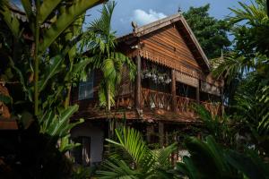 a wooden house with a balcony in the jungle at Isann Lodge in Siem Reap
