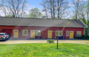 a red and yellow building with a car parked in front at 1 Bedroom Lovely Apartment In Värnamo in Värnamo