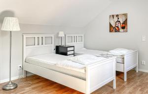 two white beds in a room with a lamp at 1 Bedroom Lovely Apartment In Värnamo in Värnamo +5 photos