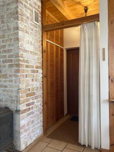 a room with a brick wall and a door with a curtain at Biały Zdrój in Kalisz Pomorski