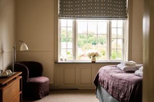 a bedroom with a bed and a window and a chair at Josty Frederiksberg in Copenhagen