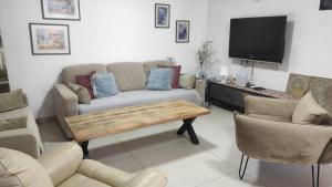 a living room with a couch and a tv at בית שבט אחים in Hatzor haglilit