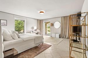 a bedroom with a white bed and a large window at Villa Seize St Tropez in Saint-Tropez +37 photos