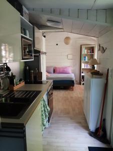 a kitchen and living room with a bed in the background at La Biro in Pornic