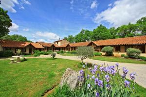 a house with a yard with purple flowers at Hostellerie du Causse in Gramat