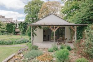 a gazebo with a table and chairs in a garden at The Roost in Westport