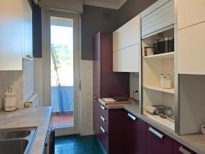 a kitchen with purple cabinets and a large window at Star Lake in Intra +12 photos