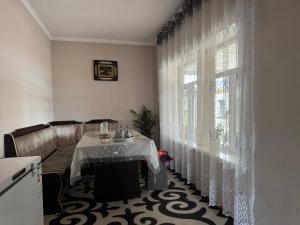 a dining room with a table and a window at Shabdan Guest House in Toktogul