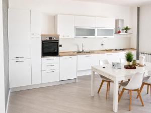 a kitchen with white cabinets and a white table at La Casa al Mare in Pescara