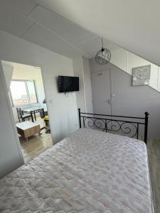 a bedroom with a bed and a tv on the wall at Villa la surprise in Le Tréport
