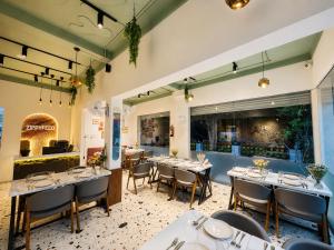 a restaurant with tables and chairs in a room at Travinities Premier, Ujjain in Ujjain