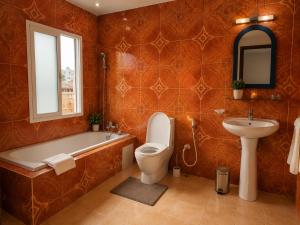 a bathroom with a tub and a toilet and a sink at appartement golf in Bamako