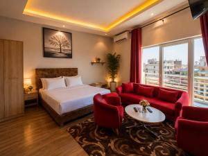 a hotel room with a bed and red chairs at appartement golf in Bamako +21 photos