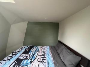 a small bedroom with a bed with a green headboard at Blue Bayou Dome Village in Dingwall