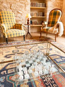 a living room with a glass table and two chairs at Domaine de la Salutière - Charme & Confort au cœur du Pays Cathare in Lauraguel +77 photos