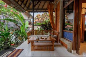 an outdoor patio with a bench and a table at Pondok Alami Villas 5BR & Pool in Ubud