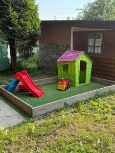 a play house with a slide and a playground at Kuća za odmor Nera in Hadžići
