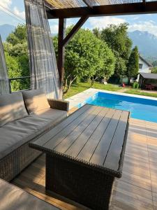 a patio with a couch and a table next to a pool at Kuća za odmor Nera in Hadžići