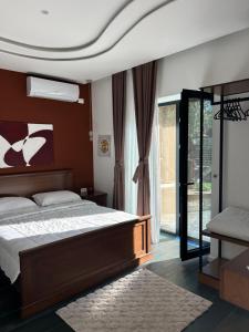 a bedroom with a bed and a large window at Villa Mucenji in Përmet