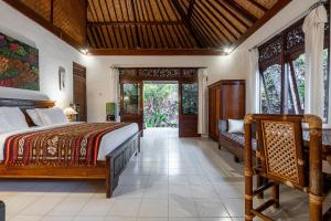 a bedroom with a bed and a couch in a room at Pondok Alami Villas 5BR & Pool in Ubud