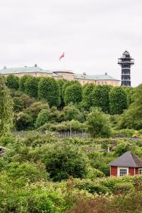 a lighthouse sitting on top of a hill with trees at Josty Frederiksberg in Copenhagen