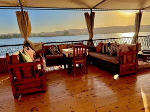 a living room with a couch and chairs on a boat at Dahabiya Queen Tyi II in Luxor