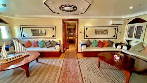 a living room with two beds and a coffee table at Dahabiya Queen Tyi II in Luxor