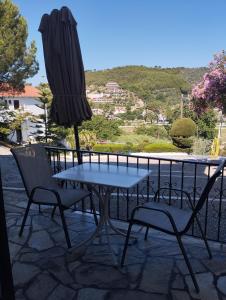 a table and chairs and an umbrella on a patio at Villa Frideriki in Agia Paraskevi