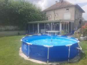 a large blue pool with a fountain in a yard at Rogozen B&B in Rogozen