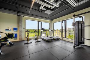 a gym with cardio equipment and windows in a building at Comfort Hotel Grimstad in Grimstad