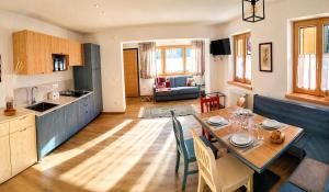 a kitchen and living room with a table and a kitchen and a dining room at Blu Betulle, Free Park and Ski room in Camporosso in Valcanale